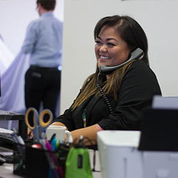 Support specialist on phone smiling