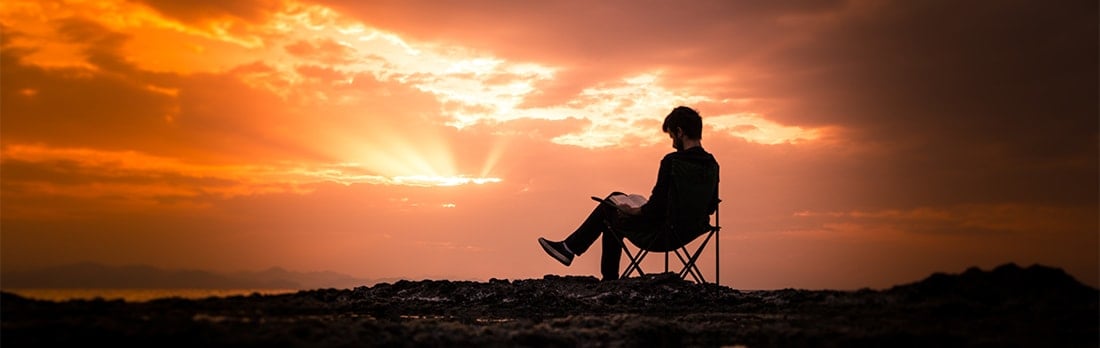 Man reading during a sunset.